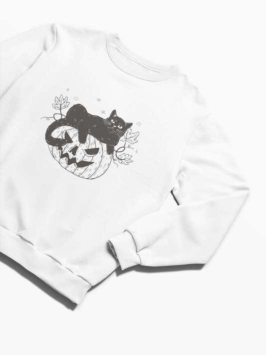 Introducing the Pumpkin Cat Sweatshirt: A cozy white sweatshirt adorned with a black illustration of a lounging cat on a carved pumpkin, surrounded by autumn leaves and stars. It's the perfect garment for cat lovers looking to embrace the spooky season in style.